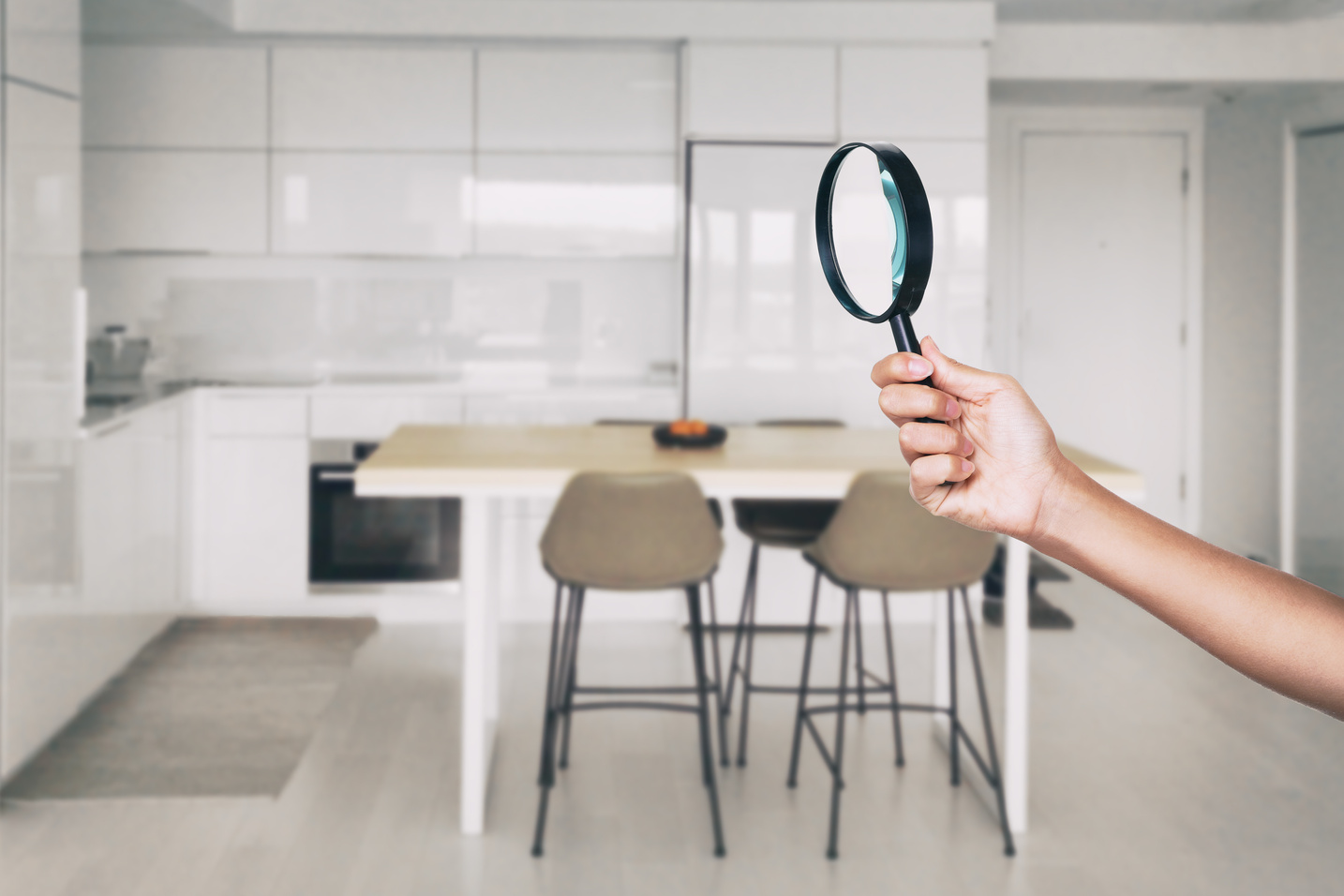 Home Inspection - Magnifying Glass Inspector Looking at Kitchen House Background